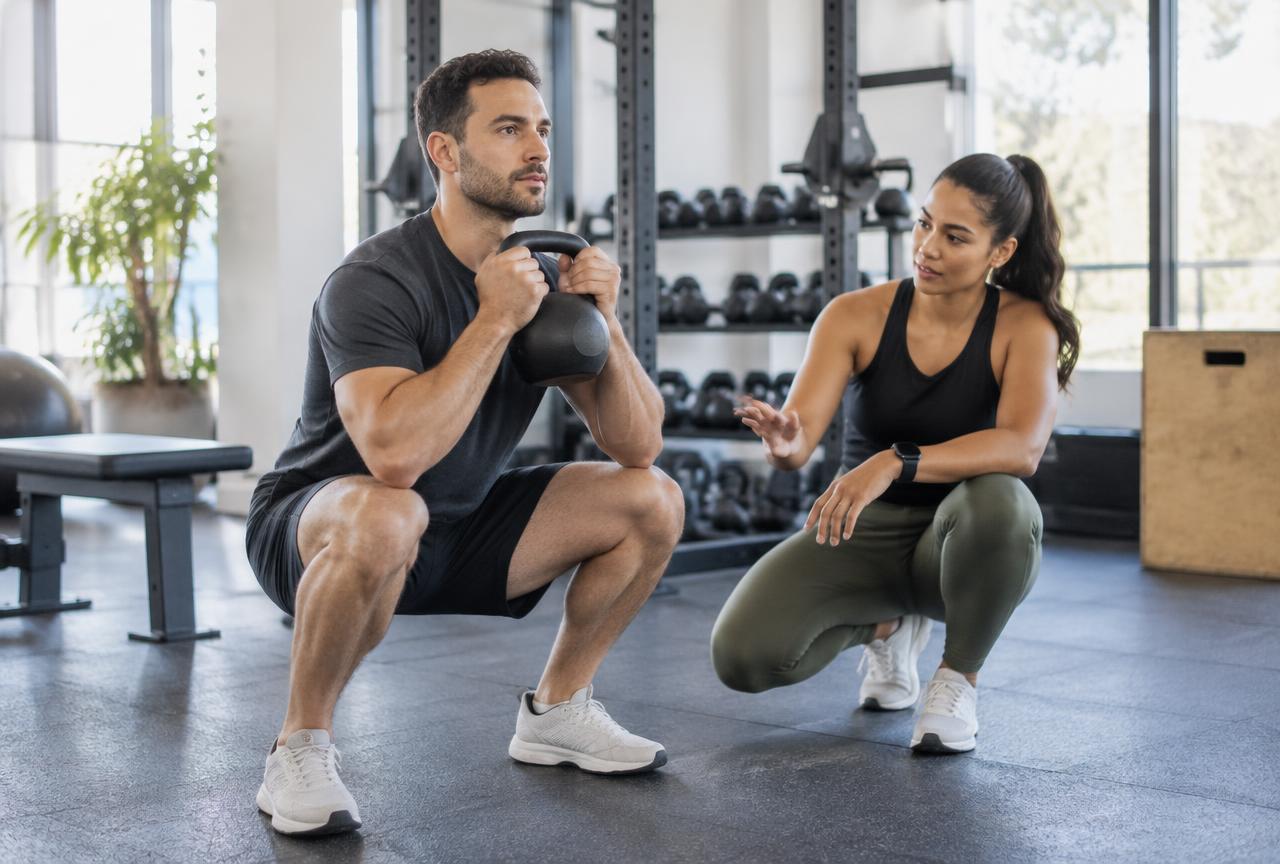 Personal trainer coaching a client during a strength session